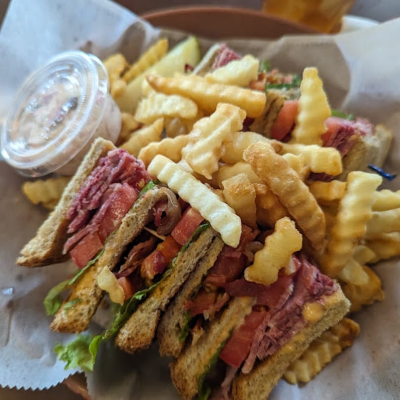A Side Street Diner club sandwich with corned beef, lettuce, tomato, and crinkle-cut fries.