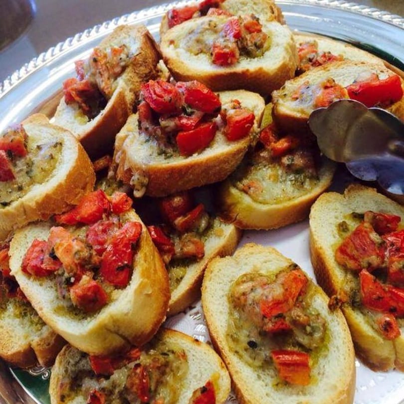 Side Street Diner's bruschetta with diced tomatoes and pesto on toasted bread, served on a silver platter.